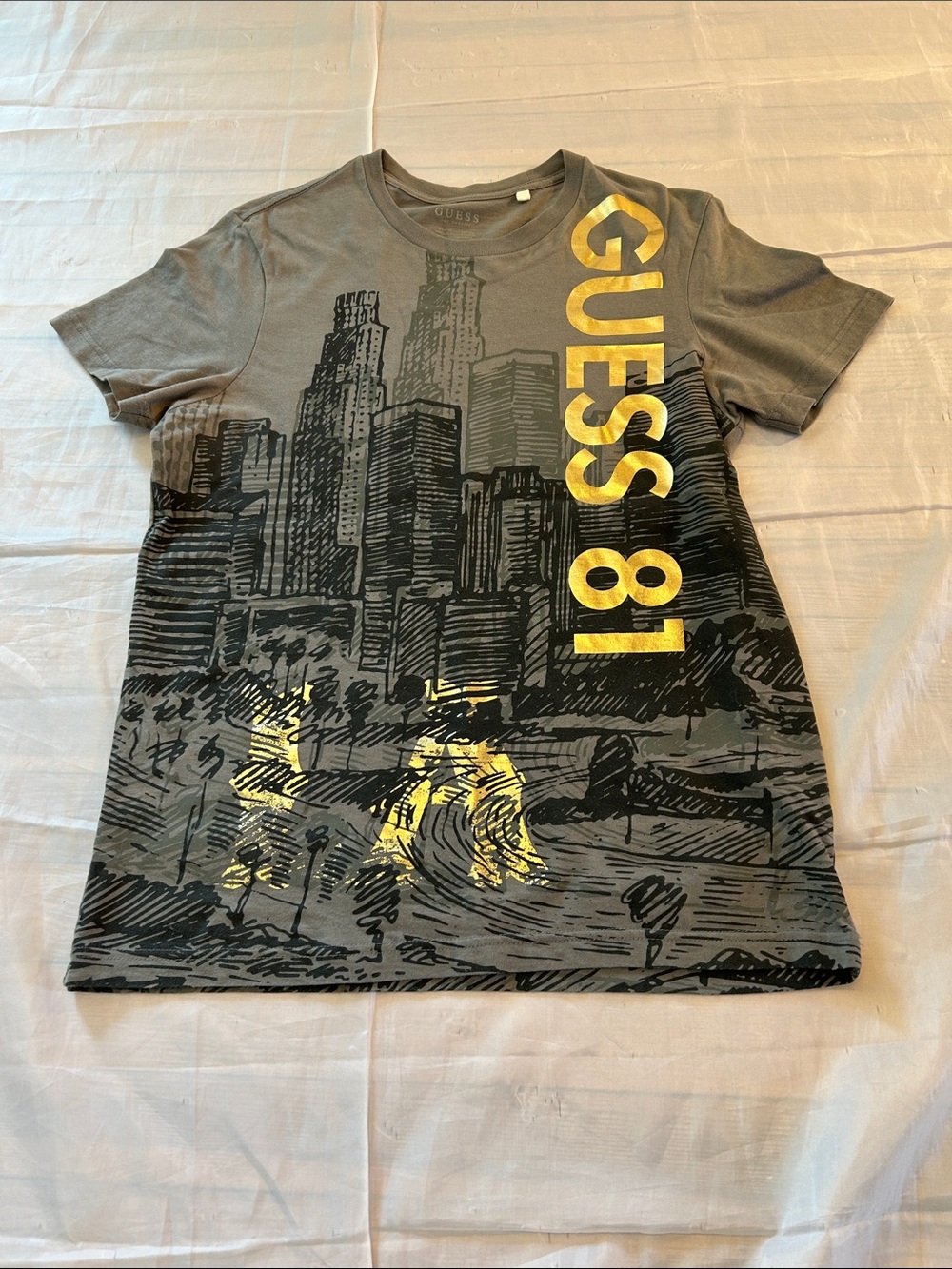 GUESS Gray Tee with Gold Vertical Logo and City Graphic